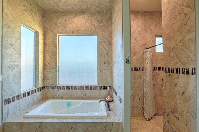 bathroom with a whirlpool tub and tiled shower