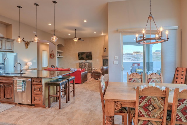 dining area featuring arched walkways, recessed lighting, and ceiling fan with notable chandelier