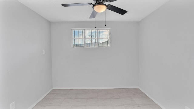 spare room with baseboards and ceiling fan