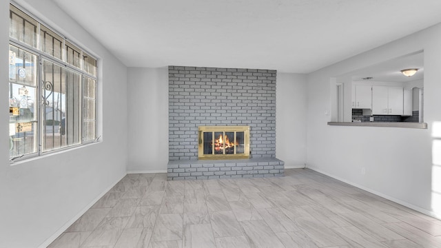 unfurnished living room featuring a fireplace and baseboards