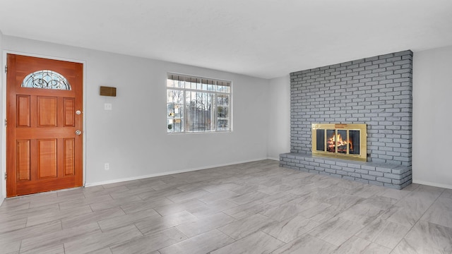 unfurnished living room with baseboards and a fireplace