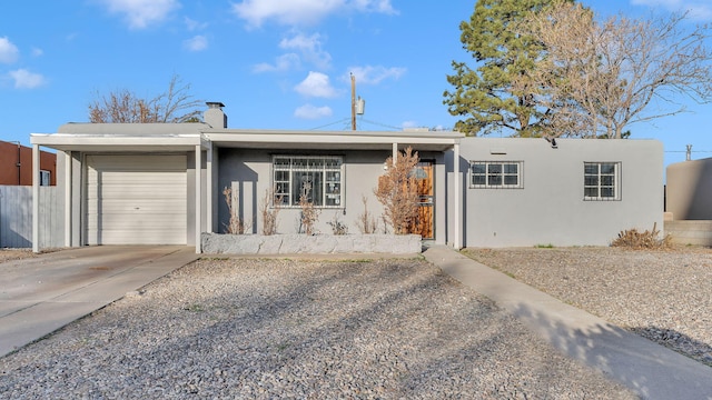 single story home with fence, driveway, an attached garage, a chimney, and stucco siding