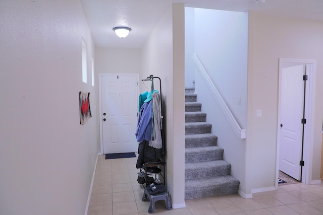 stairs featuring baseboards and tile patterned flooring