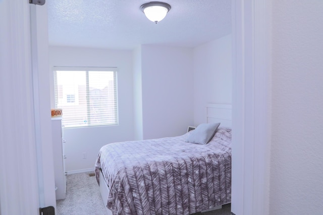 bedroom with baseboards, carpet, and a textured ceiling