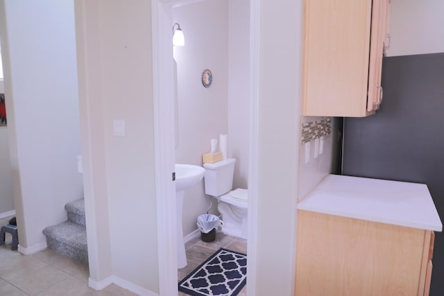 bathroom with tile patterned flooring, toilet, and baseboards