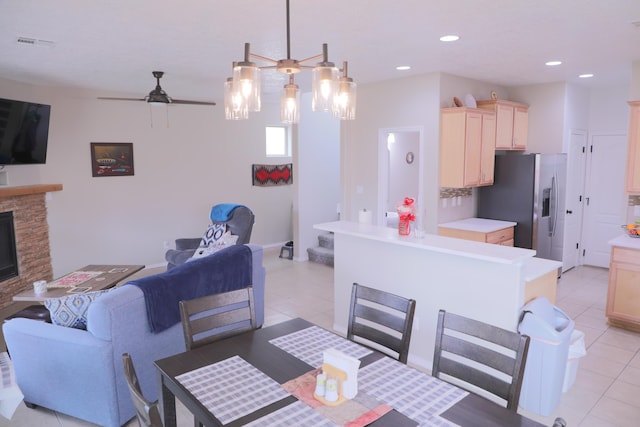 dining area with light tile patterned floors, a ceiling fan, visible vents, recessed lighting, and a stone fireplace