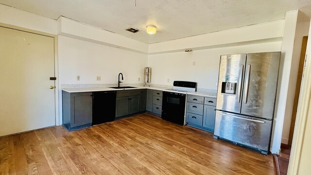 kitchen with visible vents, electric range, a sink, stainless steel fridge, and dishwasher