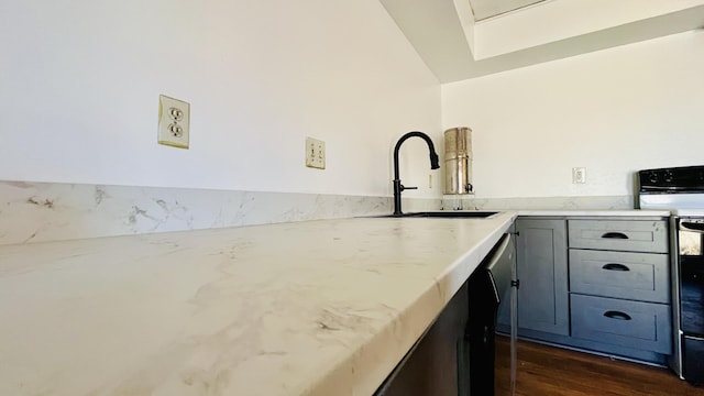 kitchen featuring dark wood-style flooring, range with electric stovetop, gray cabinets, a sink, and light stone countertops