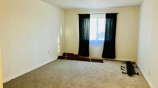 spare room with carpet and baseboards