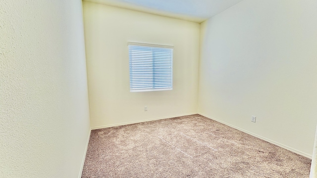 carpeted empty room with baseboards