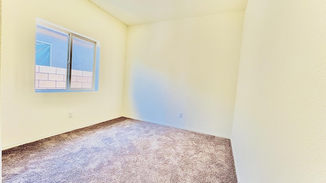 carpeted spare room featuring baseboards