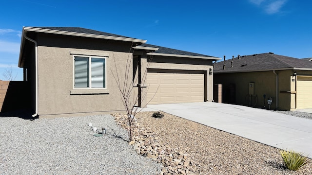 view of front of home with a garage, driveway, roof with shingles, and stucco siding