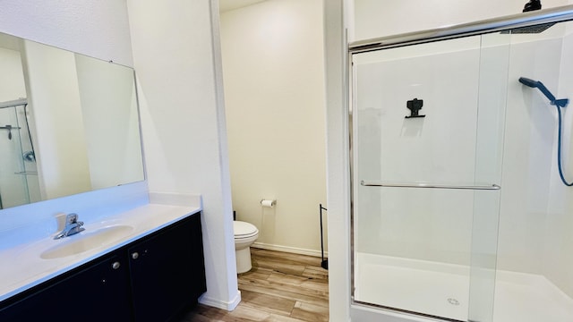 full bathroom with vanity, a stall shower, wood finished floors, and toilet