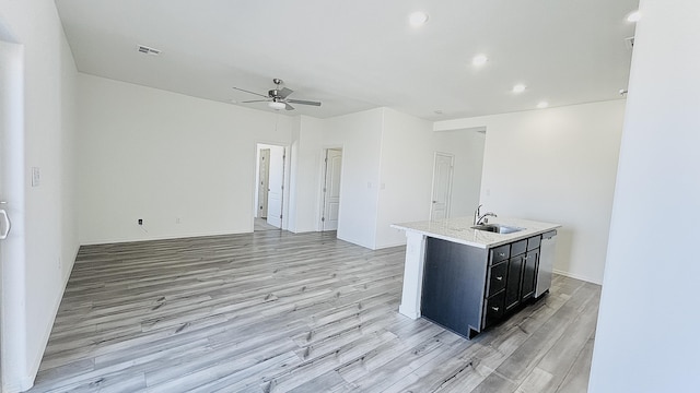 5030 Grace St, Los Lunas, NM 87031 - kitchen with a ceiling fan, light wood finished floors, open floor plan, dark cabinetry, and recessed lighting