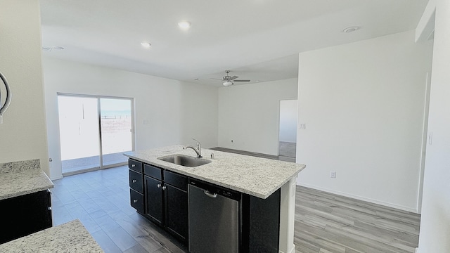 5030 Grace St, Los Lunas, NM 87031 - kitchen featuring stainless steel dishwasher, dark cabinetry, light wood finished floors, and a kitchen island with sink