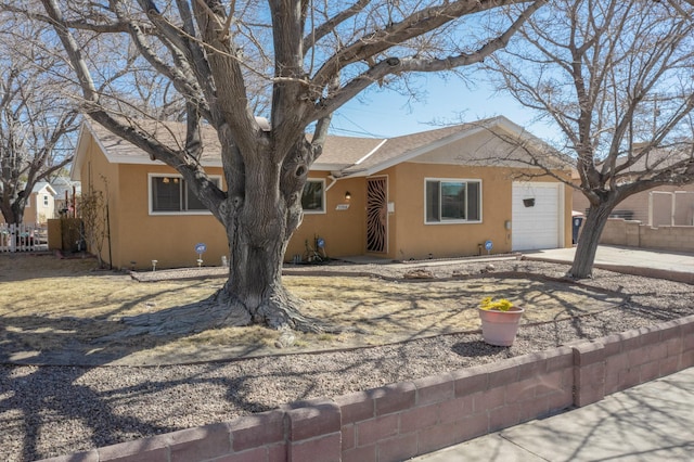 view of front of property featuring an attached garage, a shingled roof, fence, concrete driveway, and stucco siding