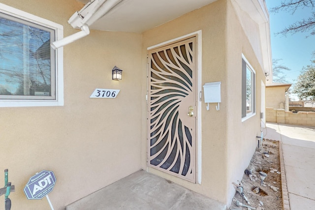 property entrance with stucco siding