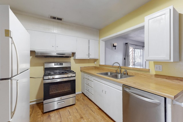 kitchen featuring under cabinet range hood, a sink, visible vents, light countertops, and appliances with stainless steel finishes