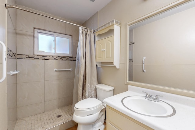 bathroom featuring toilet, a shower stall, and vanity