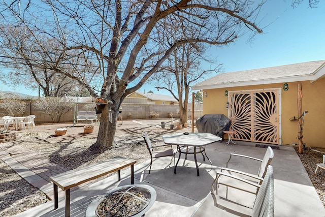 view of patio / terrace featuring an outdoor fire pit, a grill, a fenced backyard, and outdoor dining space