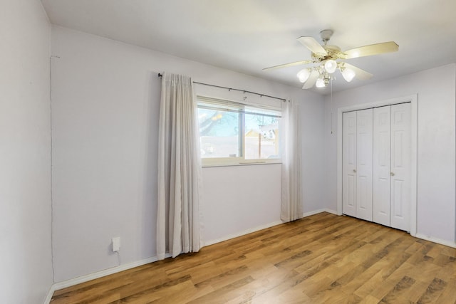 unfurnished bedroom featuring baseboards, ceiling fan, a closet, and light wood-style floors