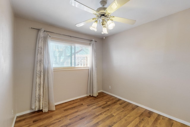 unfurnished room featuring ceiling fan, baseboards, and wood finished floors