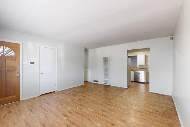 interior space featuring light wood-style floors, visible vents, and baseboards