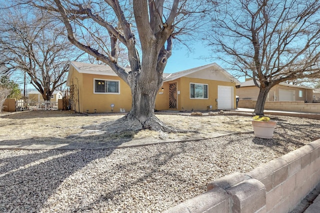 view of front of house with fence and stucco siding