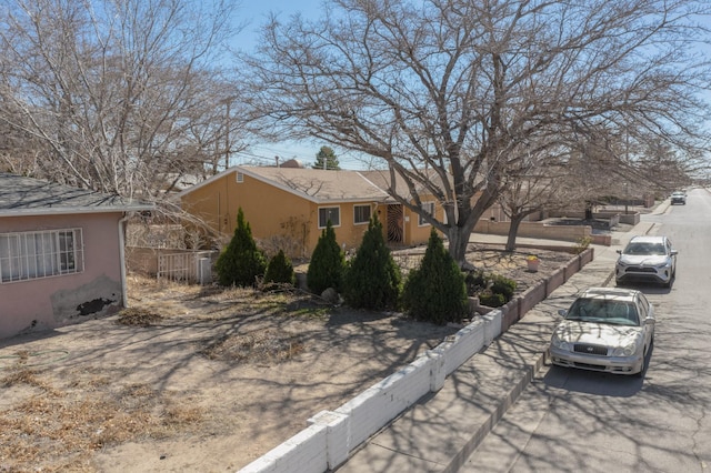 view of property exterior featuring fence and stucco siding