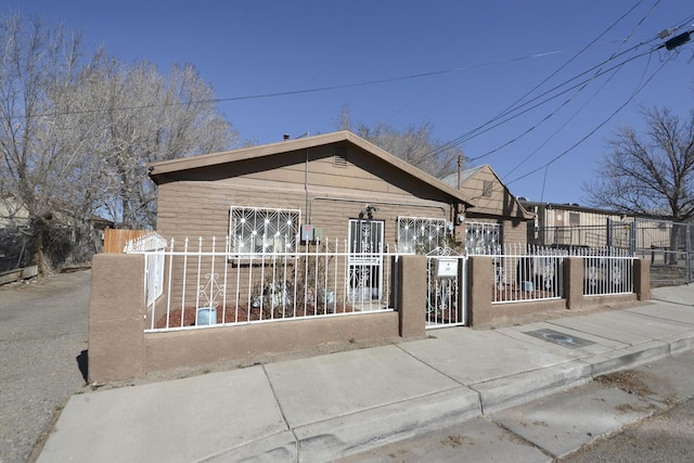 bungalow featuring a fenced front yard and a gate