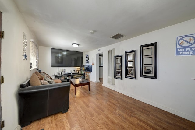 living area featuring light wood-type flooring, baseboards, and visible vents