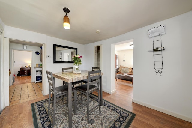 dining space with baseboards and wood finished floors