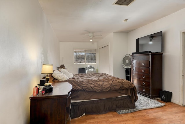 bedroom featuring ceiling fan, wood finished floors, and visible vents