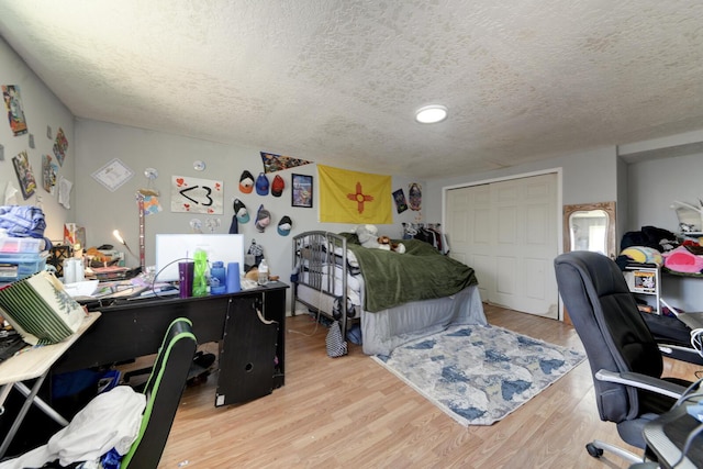 bedroom featuring a textured ceiling and wood finished floors