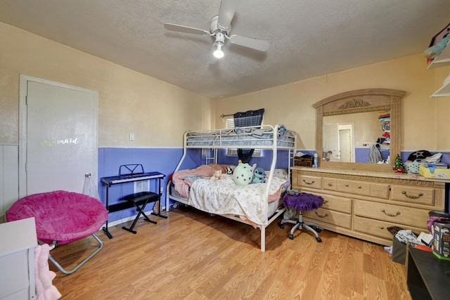 bedroom featuring light wood-type flooring, ceiling fan, and a textured ceiling