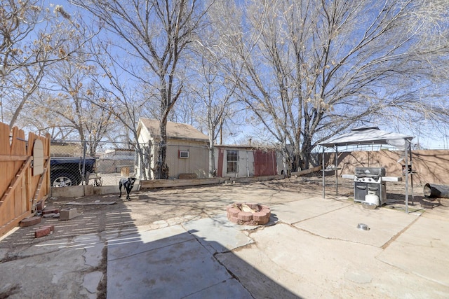 view of patio / terrace featuring an outdoor structure, a fenced backyard, a grill, and a gazebo