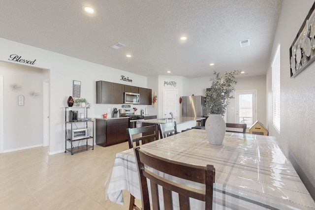 dining area featuring a textured ceiling, baseboards, visible vents, and recessed lighting