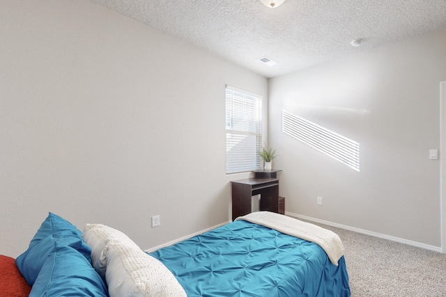 carpeted bedroom featuring visible vents, a textured ceiling, and baseboards