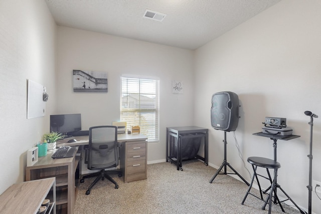 office area featuring baseboards, visible vents, a textured ceiling, and light colored carpet