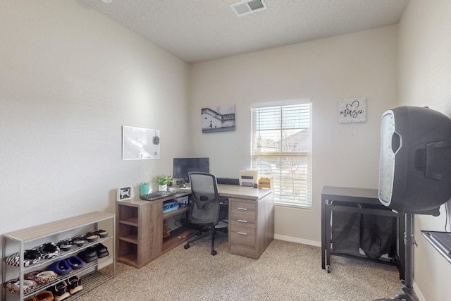 home office featuring baseboards, a textured ceiling, visible vents, and light colored carpet