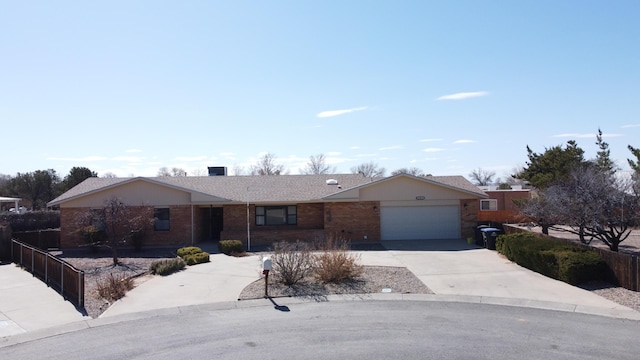 single story home with a garage, fence, concrete driveway, and brick siding