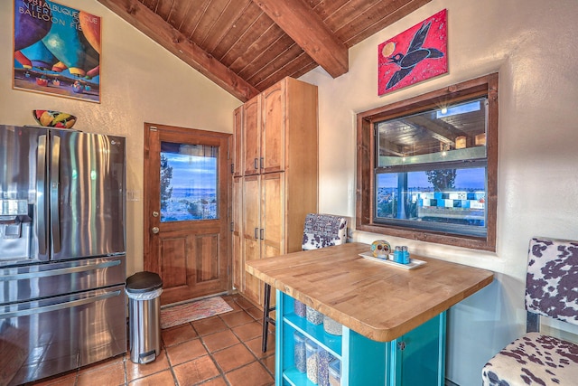 kitchen featuring vaulted ceiling with beams, wooden ceiling, wooden counters, stainless steel refrigerator with ice dispenser, and tile patterned floors