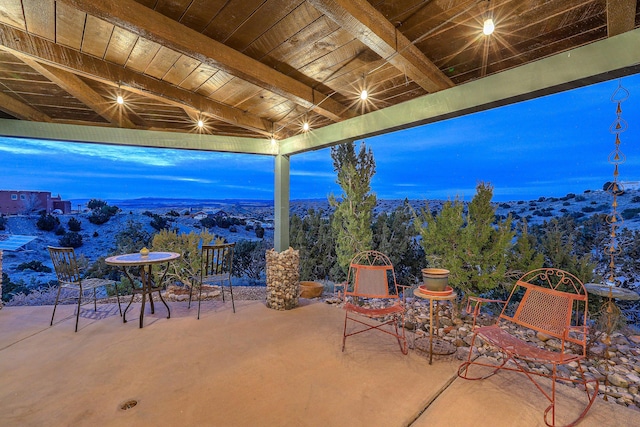 view of patio / terrace featuring outdoor dining area and a wooded view