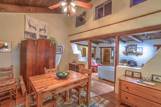 tiled dining area featuring wood ceiling, beam ceiling, and a ceiling fan