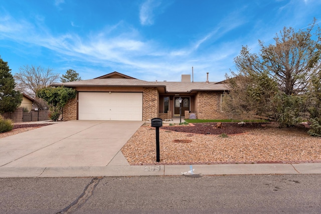 ranch-style home featuring a garage, concrete driveway, brick siding, and fence