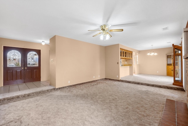 interior space with ceiling fan with notable chandelier, french doors, carpet flooring, and visible vents