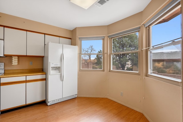 kitchen with white appliances, visible vents, white cabinets, light wood-style flooring, and light countertops