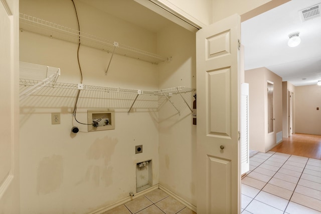 washroom featuring light tile patterned floors, hookup for a washing machine, visible vents, electric dryer hookup, and laundry area