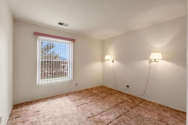 carpeted empty room with a textured ceiling and visible vents