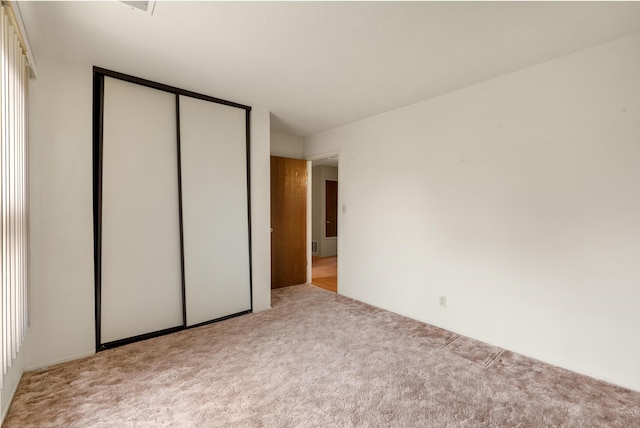 unfurnished bedroom with a closet and carpet flooring